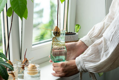 Midsection of woman holding drink on table