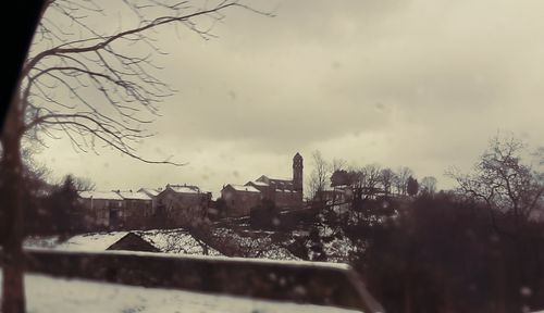 Buildings in city against cloudy sky