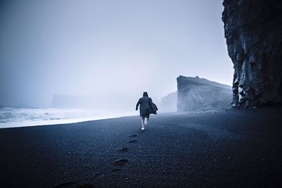 Man standing on beach against sky