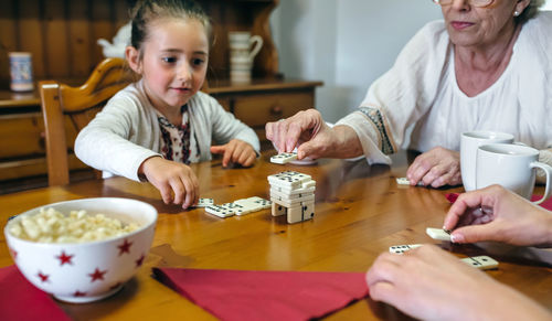 Close-up of hands holding food while sitting on table