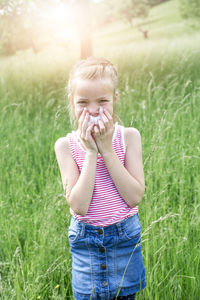 Girl sneezing while standing on field