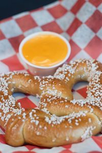 Close-up of pretzel with cheese in paper