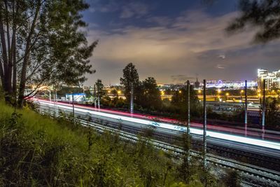 Light trails on road against sky at night