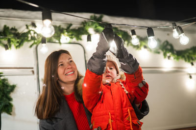 Caucasian woman and son decorate camper for christmas. happy family travels in a mobile home