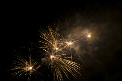 Low angle view of firework display at night