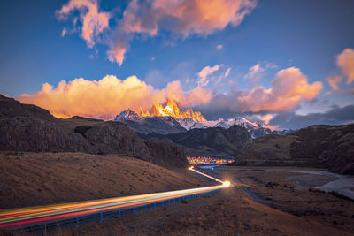 Light trails on road against sky during sunset