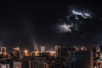 Illuminated city against sky at night