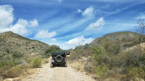 Panoramic view of vehicle on field against sky