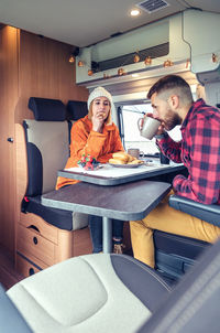 Friends having breakfast in a camper van