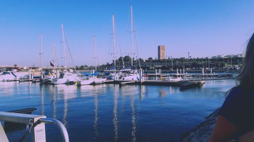 Sailboats moored in harbor