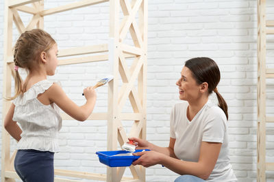 Side view of a girl standing against the wall