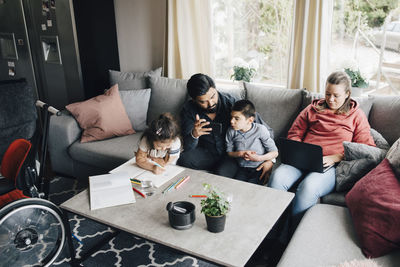 High angle view of family sitting in living room at home