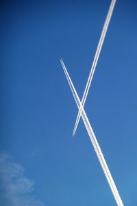 Low angle view of vapor trail against blue sky
