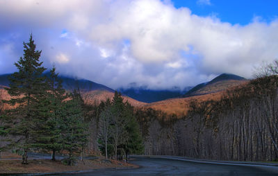 Country road against cloudy sky