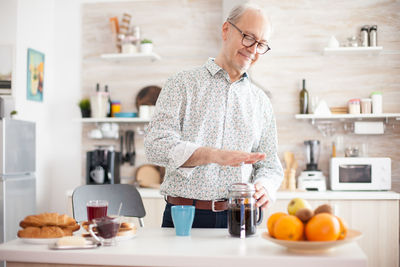 Senior man preparing coffee at home