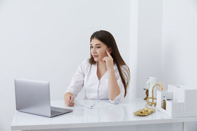 Young woman using laptop at table