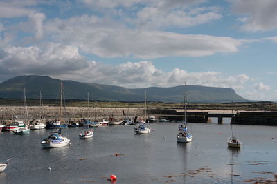 Boats moored in lake against sky