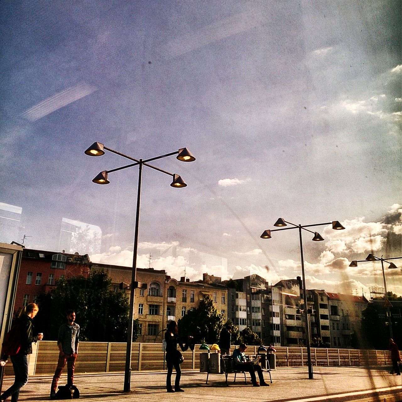 building exterior, street light, sky, street, built structure, architecture, city, road, city life, illuminated, lighting equipment, cloud - sky, car, city street, transportation, dusk, outdoors, land vehicle, incidental people