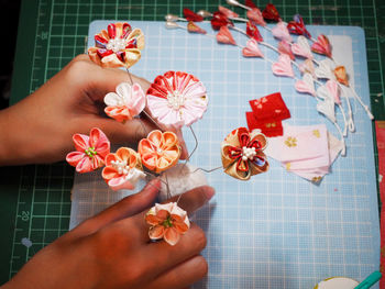 Cropped hands holding artificial flowers