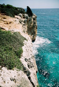 Rock formation in sea against sky