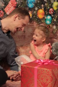 Portrait of a smiling girl sitting on christmas tree