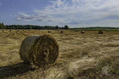 Hay bales on field against sky