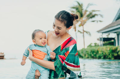 Mother and son with daughter in water