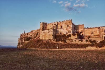 Low angle view of fort on field against sky
