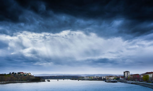 Scenic view of river against cloudy sky