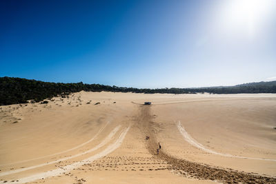 Scenic view of beach against clear blue sky