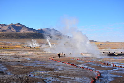 People at hot spring against mountain