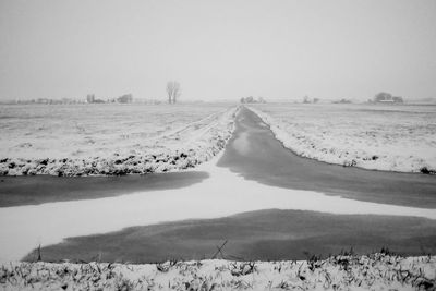 Scenic view of snow covered field against sky