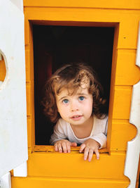 Blue-eyed girl playing in the dollhouse.