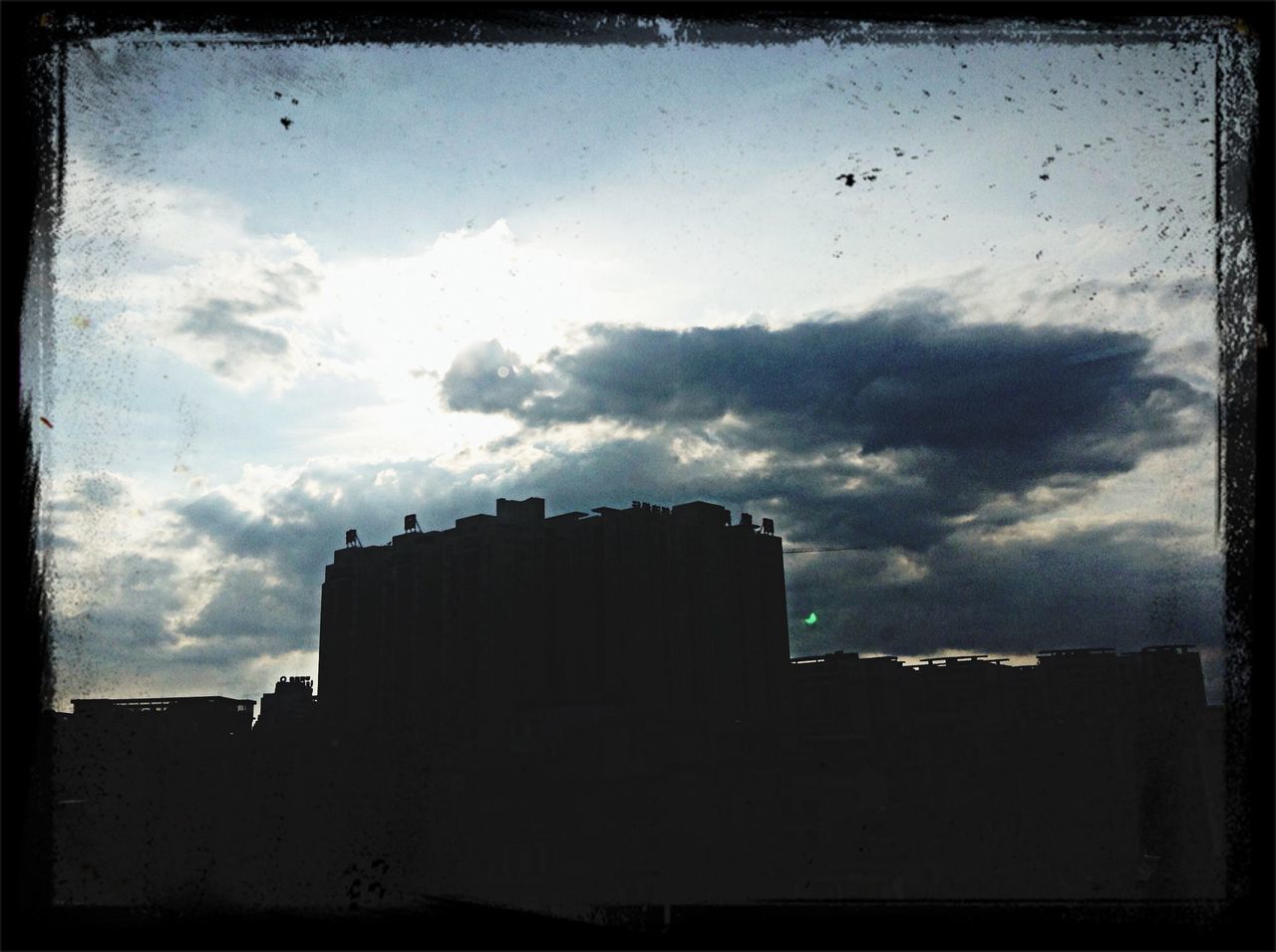 building exterior, architecture, built structure, sky, transfer print, cloud - sky, auto post production filter, low angle view, silhouette, city, building, dusk, bird, cloud, cloudy, outdoors, residential building, animal themes, flying, residential structure