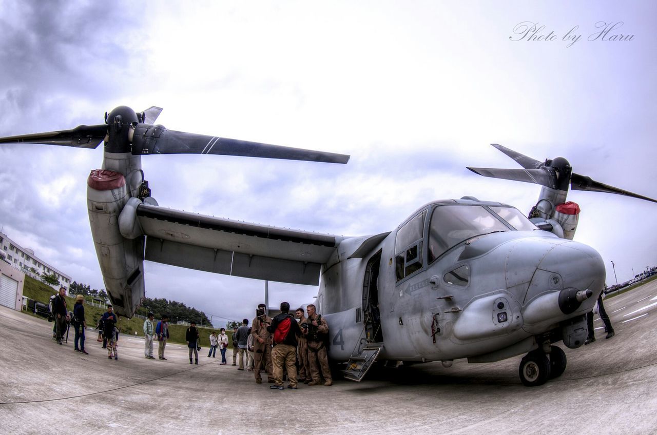 sky, transportation, mode of transport, low angle view, cloud - sky, travel, air vehicle, airplane, cloudy, land vehicle, day, men, cloud, incidental people, military, outdoors, public transportation, on the move, built structure