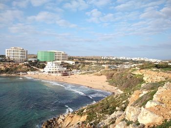 Cityscape by sea against sky