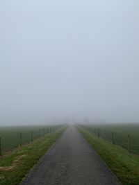 Road passing through landscape against sky