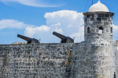 Low angle view of cannons in castle against sky