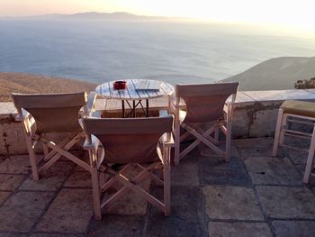 Chairs and tables on beach against sky