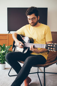 Man playing guitar at home