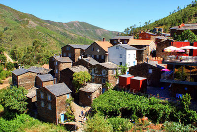 Houses by buildings in town against clear sky