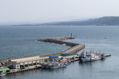 High angle view of a port with sailboats in sea against sky