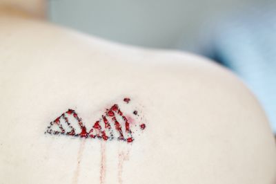 Close-up of blood and tattoo on shoulder