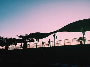Silhouette people on beach against clear sky