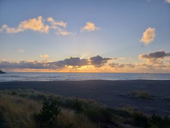 Scenic view of beach against sky during sunset