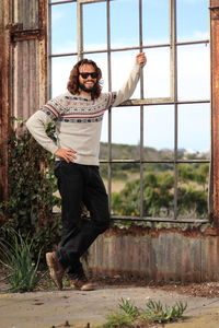 Portrait of man standing against window