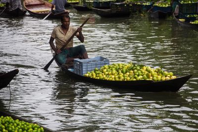 A green guava seller on his boat in floating guava market in barishal.