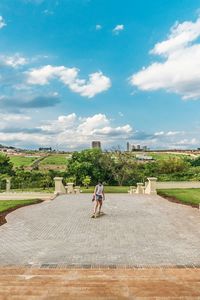 Woman with umbrella against sky