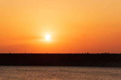Scenic view of sea against orange sky