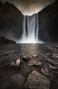 Scenic view of waterfall against sky